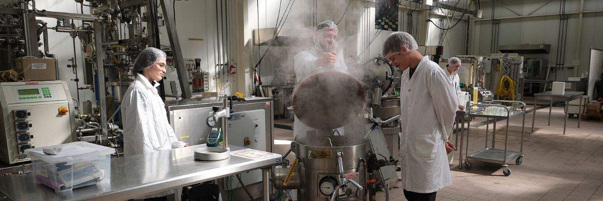 Deux techniciens agroalimentaires actionnant une machine dans une entreprise